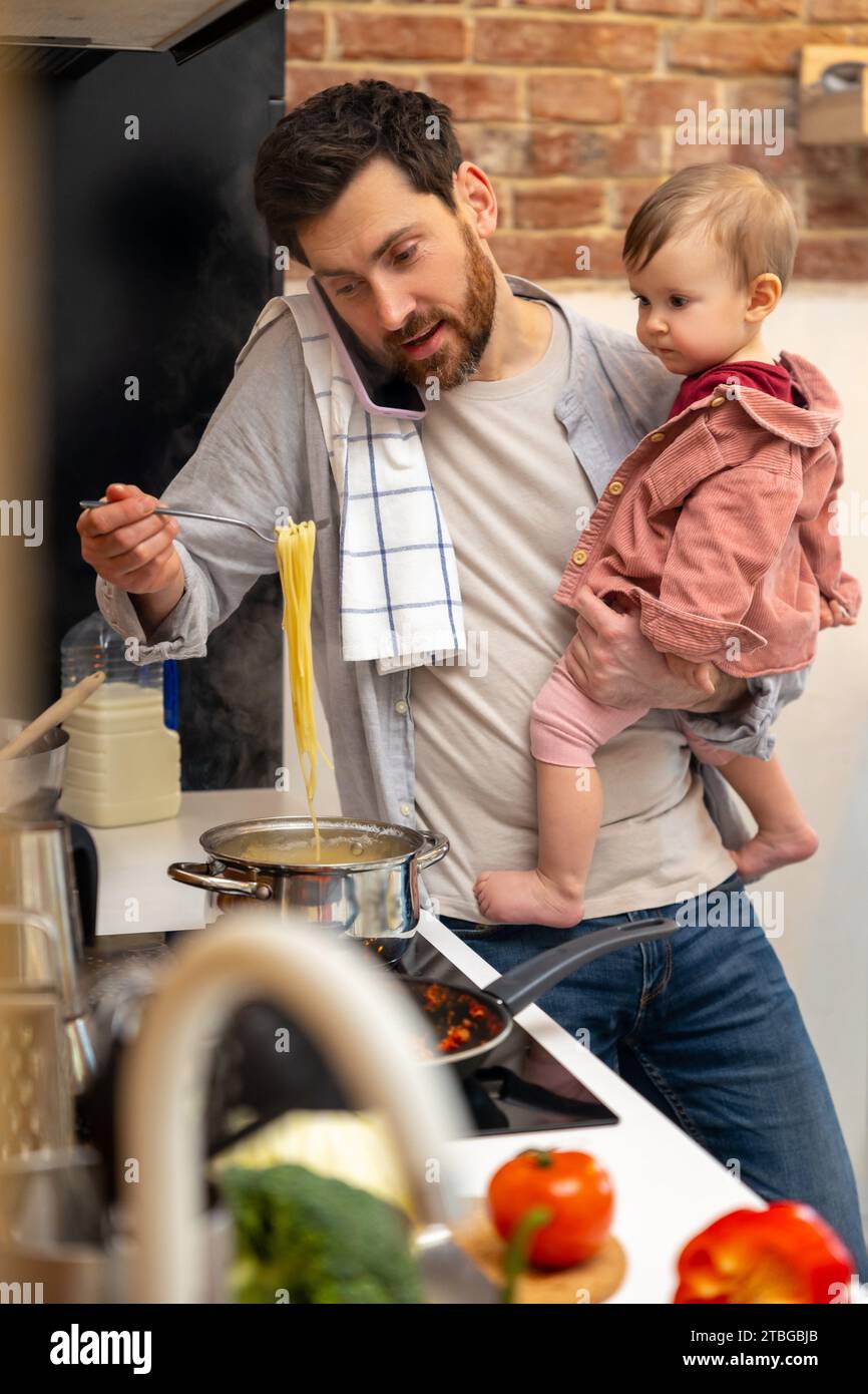Ein beschäftigter Vater kümmert sich um ein Mädchen, das Essen macht