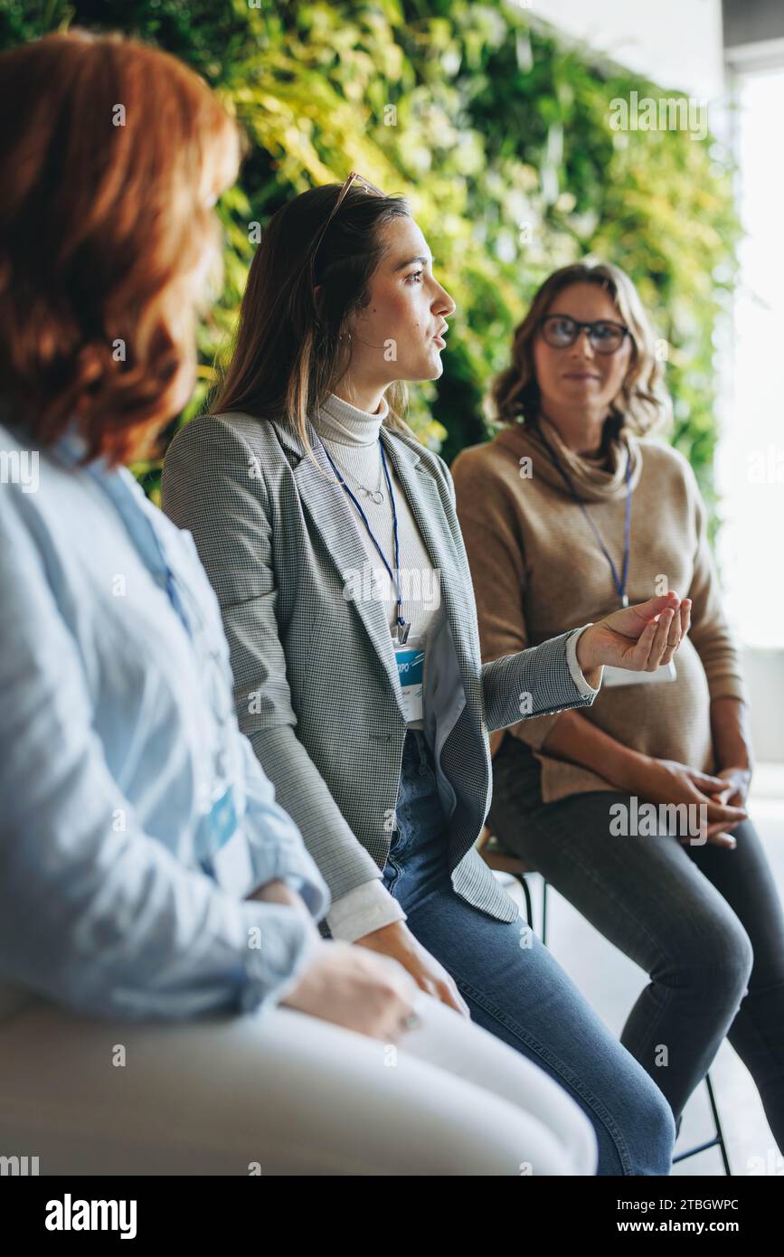 Junge Geschäftsfrauen haben während einer Podiumsdiskussion in einem Büromeeting produktiv diskutiert. Ihre Teamarbeit glänzt bei der Teilnahme an einer Konferenz Stockfoto