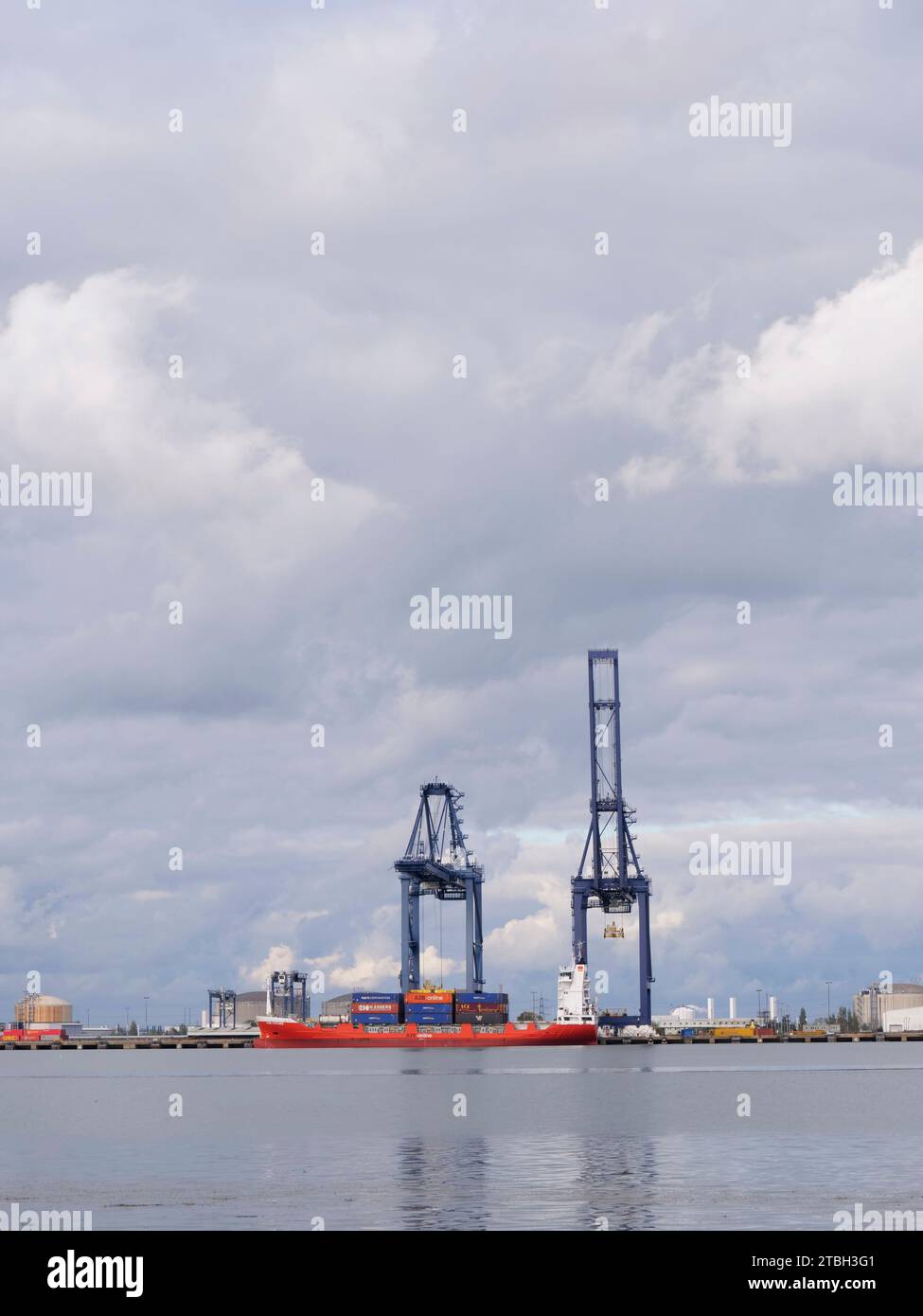 Ein kleines Containerschiff, das im Thames Port am River Medway in Kent, Großbritannien, vor Anker liegt, lädt und entlädt Frachtcontainer Stockfoto