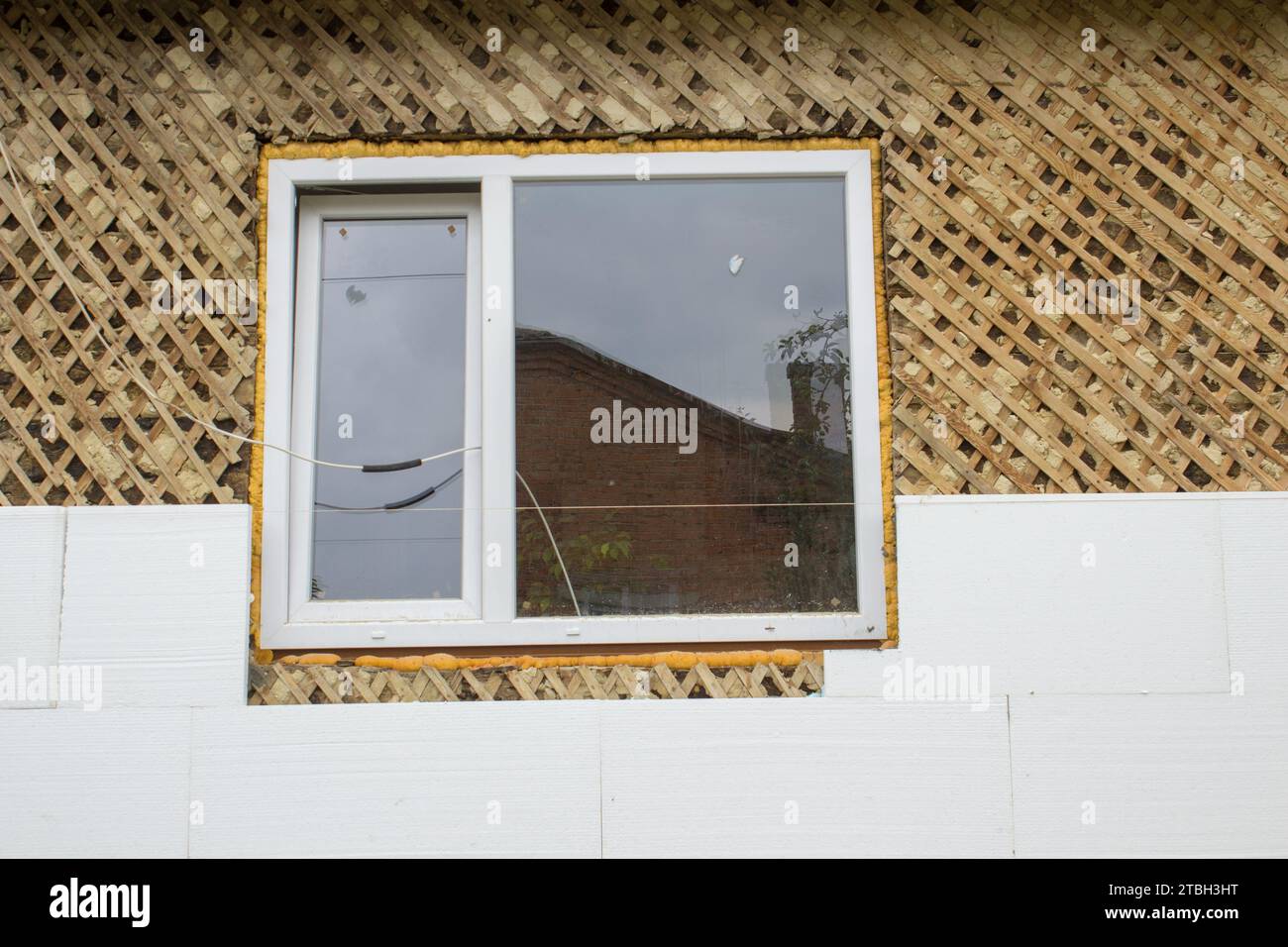 Isolieren Sie das Holzhaus aus Styropor von den Fenstern Stockfoto