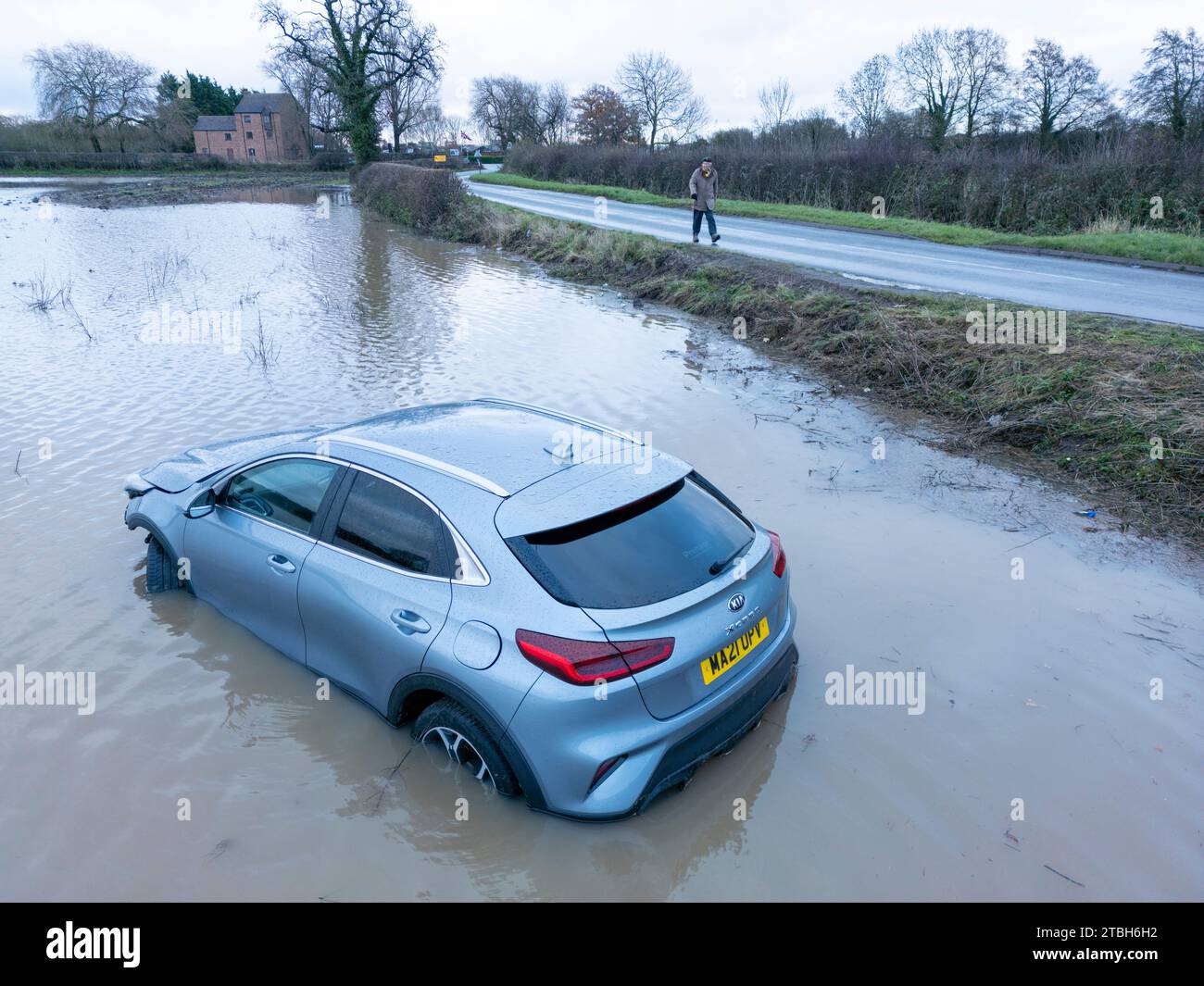 Ein Auto fährt von der Old Holly Lane in überflutete Felder in der Nähe von Atherstone. Der River Anker platzt über seine Ufer und überschwemmt Felder entlang der Sheepy Road an der Grenze zu Warwickshire, Leicestershire. Stockfoto