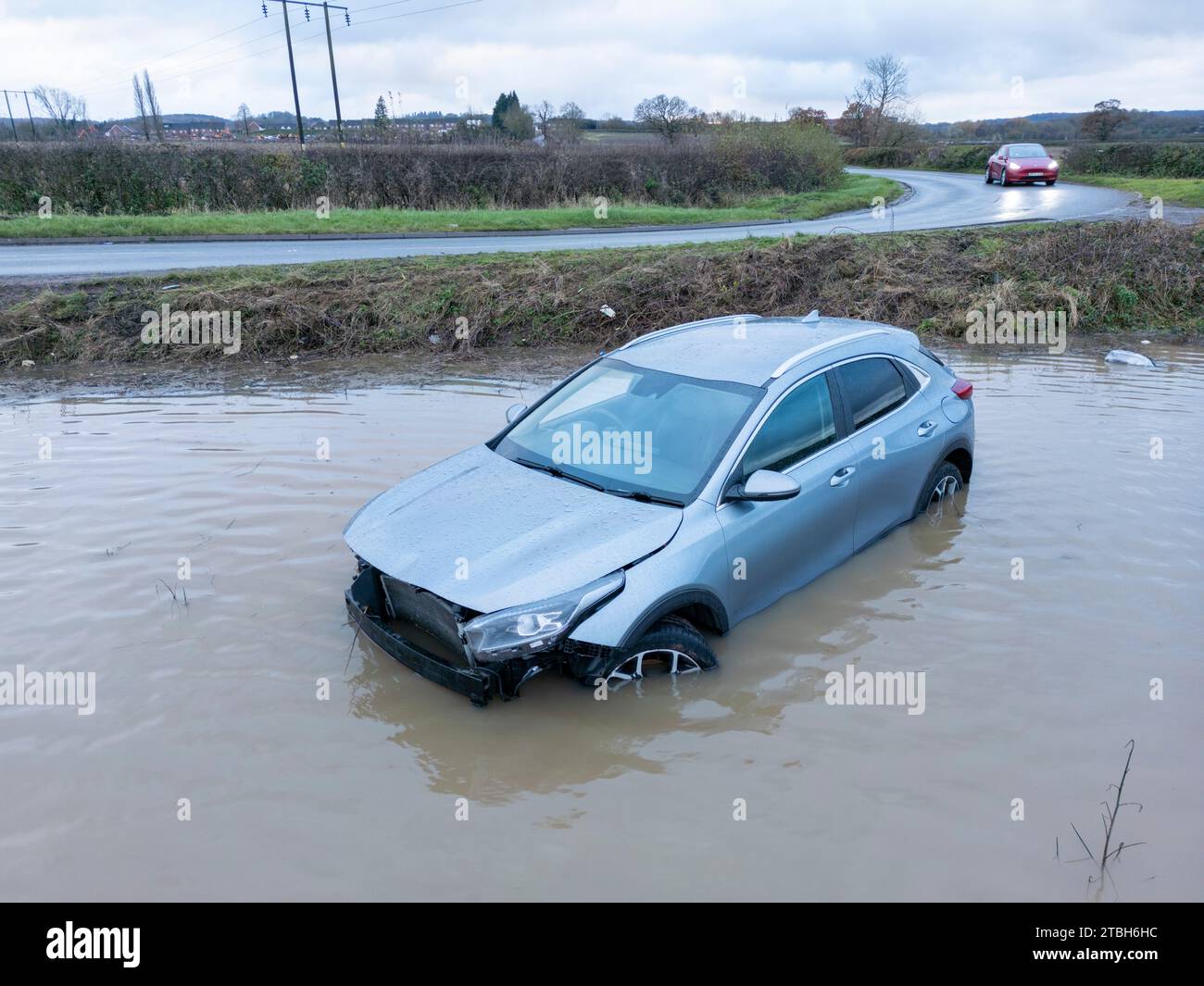 Ein Auto fährt von der Old Holly Lane in überflutete Felder in der Nähe von Atherstone. Der River Anker platzt über seine Ufer und überschwemmt Felder entlang der Sheepy Road an der Grenze zu Warwickshire, Leicestershire. Stockfoto