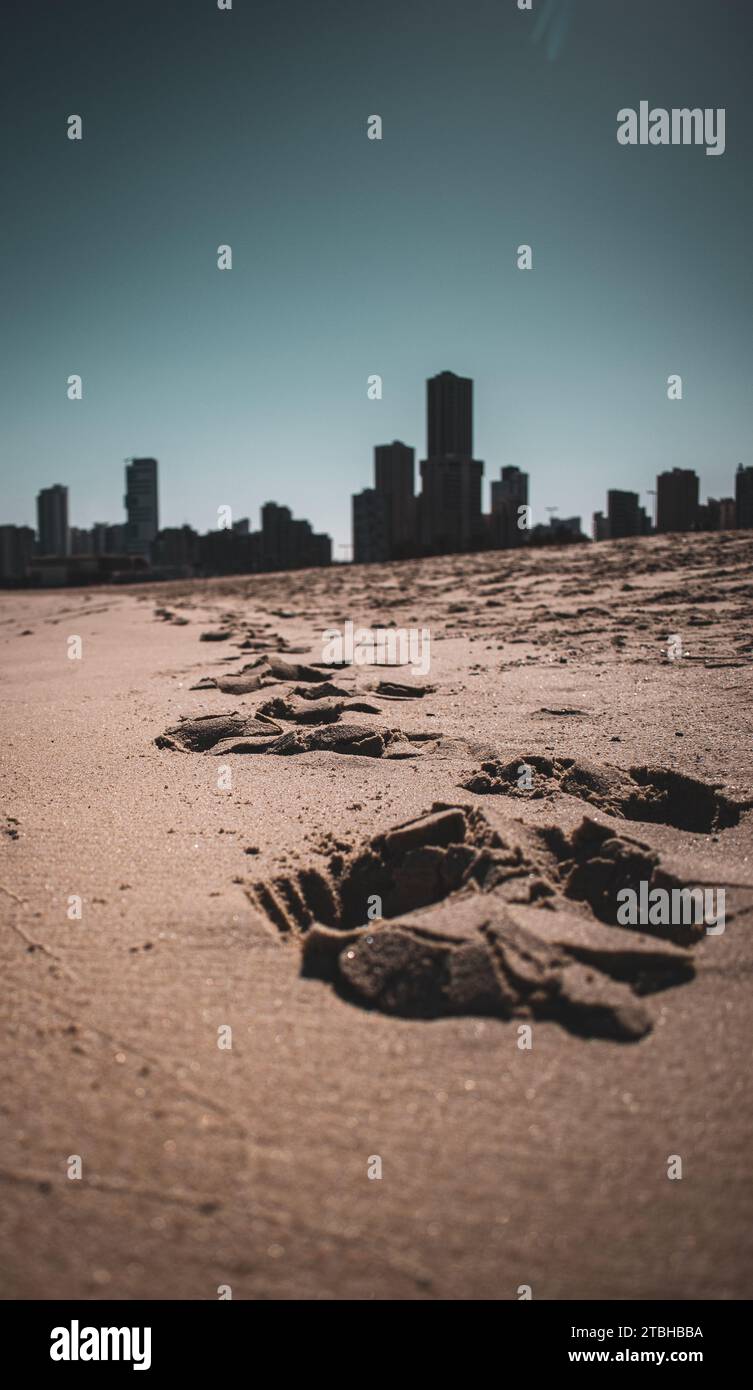 Das Ufer eines Strandes mit einer pulsierenden Skyline der Stadt im Hintergrund in Gulf Street, Kuwait Stockfoto