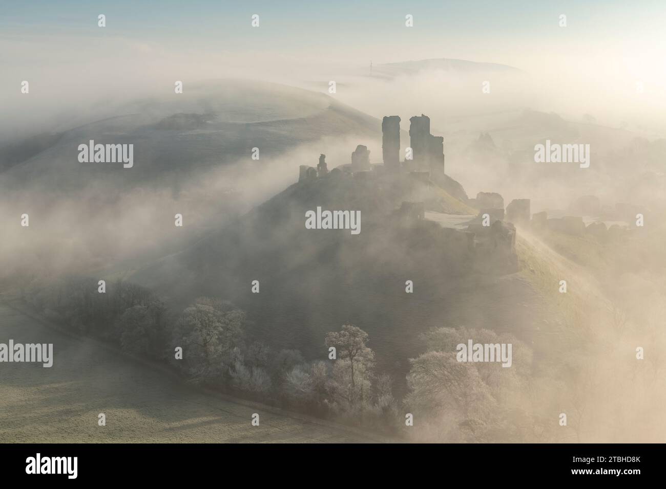 Corfe Castle taucht an einem frostigen winterlichen Morgen aus Nebel auf, Dorset, England. Winter (Februar) 2023. Stockfoto