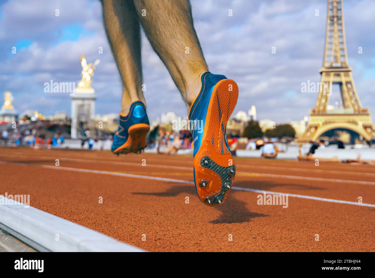 Niedriges Foto eines Kurzstreckenläufers auf einer roten, tartanierten Lauffläche mit Pariser Wahrzeichen, die sich im unscharfen Bokeh-Hintergrund zusammensetzen, verwandt mit Paris Stockfoto