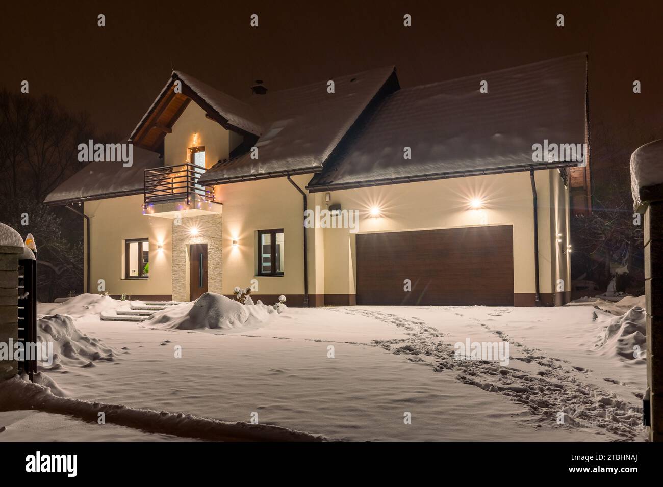 Einfamilienhaus mit Garage in Winterlandschaft bei Nacht Stockfoto