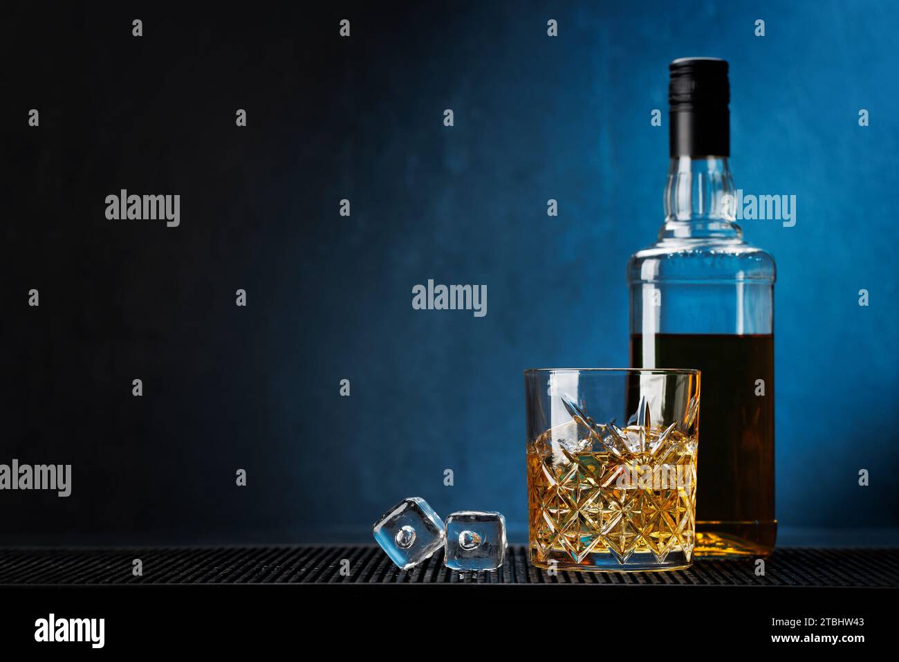 Whiskey mit kristallklaren Eiswürfeln. Glas und Flasche. Mit Kopierraum Stockfoto