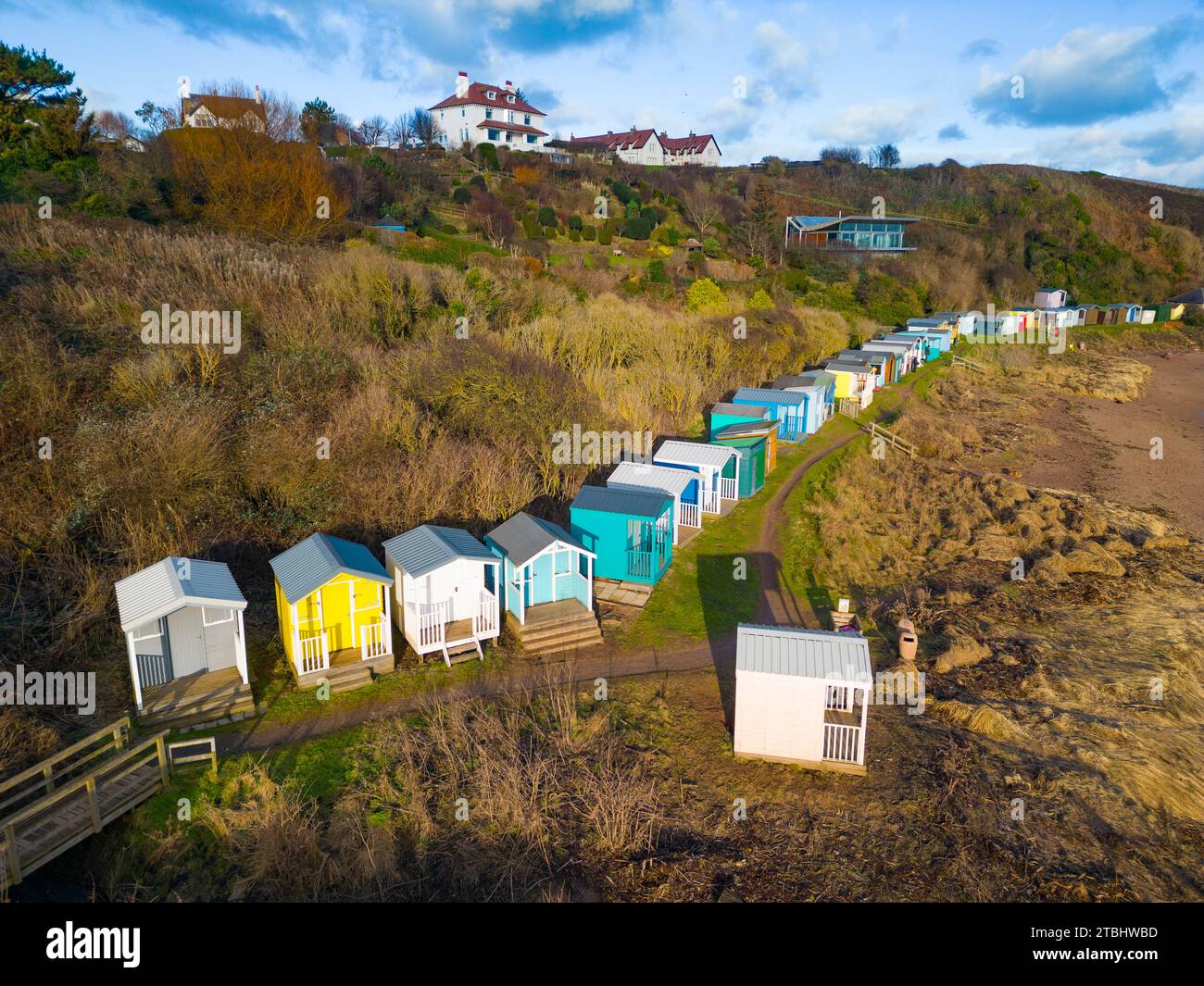 Aus der Vogelperspektive der farbenfrohen Strandhütten am Strand in Coldingham Bay in Scottish Borders, Schottland, Großbritannien Stockfoto