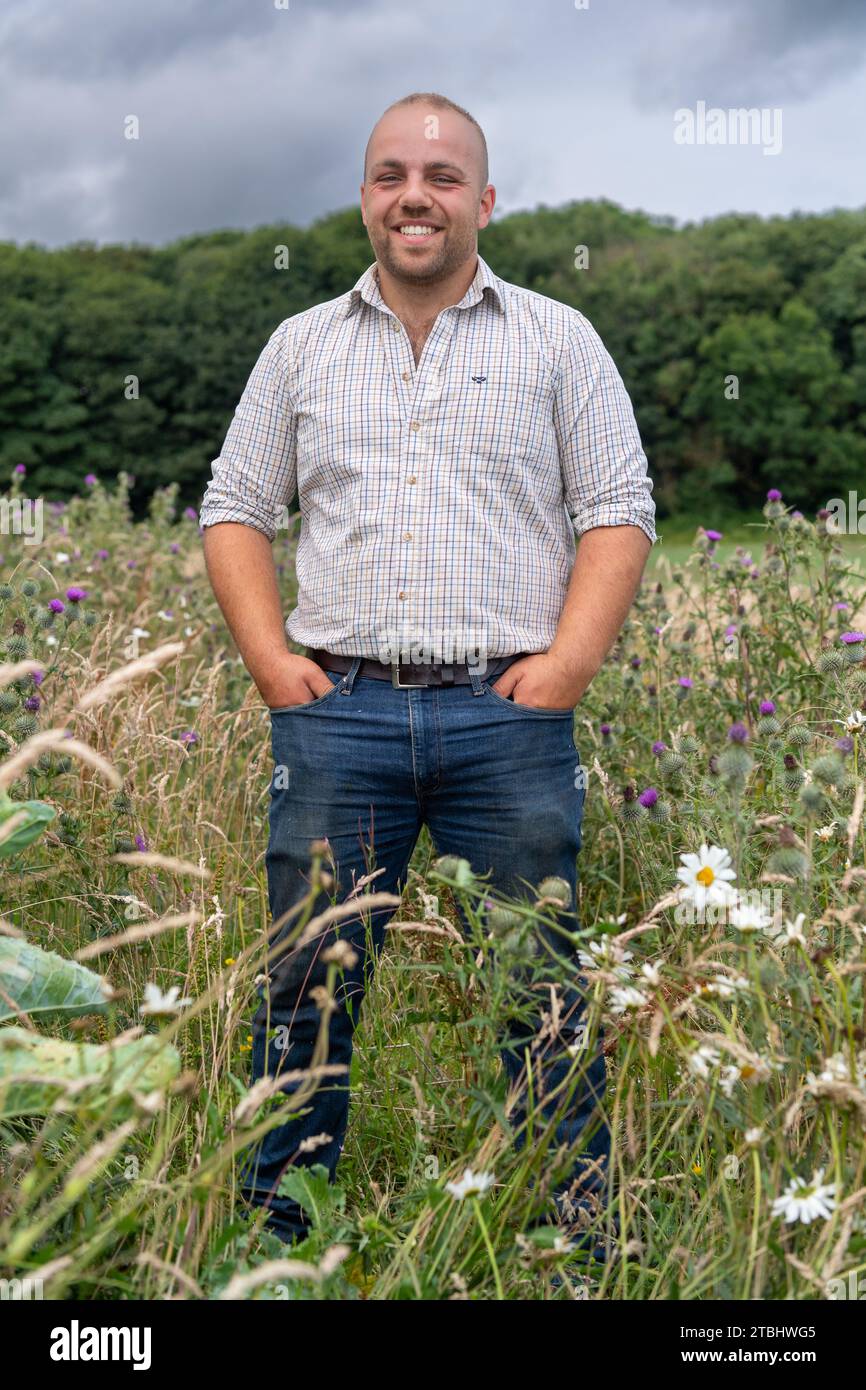 Landwirt in einem Blütenstreifen am Rande seines Feldes, der zur Förderung von Insekten und Wildtieren angebaut wird. Co. Durham, Großbritannien. Stockfoto