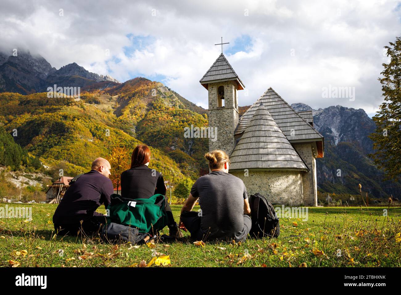 Kleine Gruppe von Touristen, die auf einer Wiese in Theth, Albanien, sitzen Stockfoto