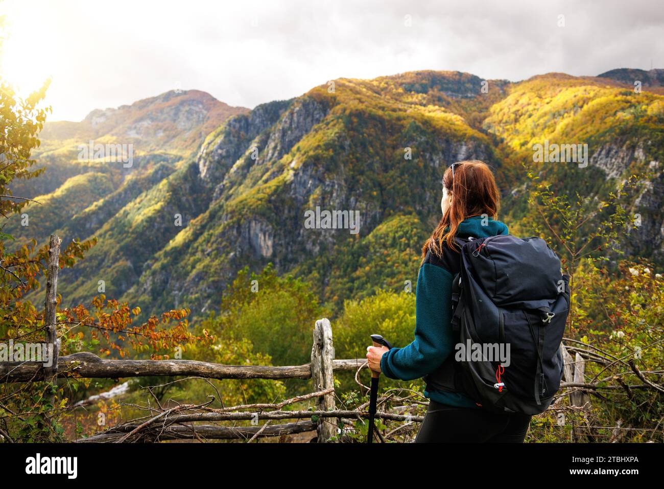 Frau, die in den albanischen Alpen wandert und einen Berg in wunderschönen Herbstfarben betrachtet Stockfoto