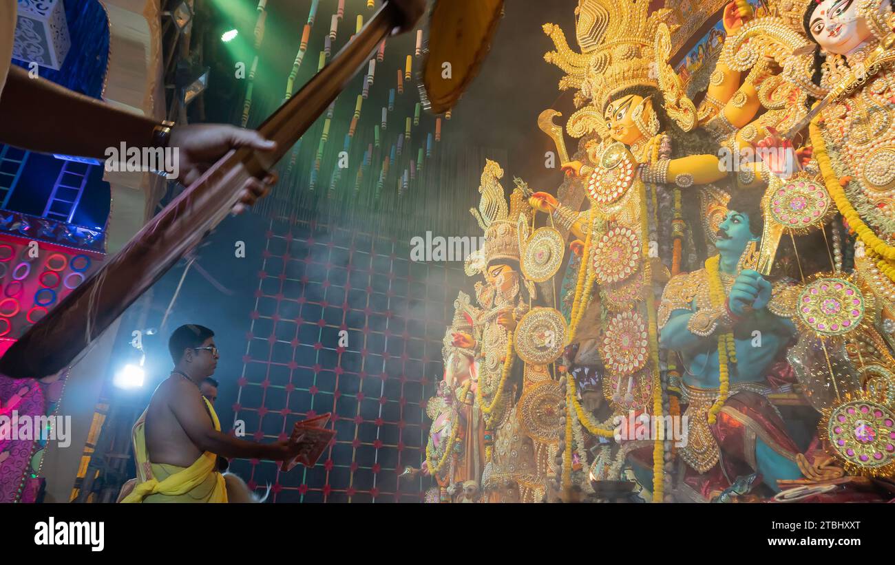 Howrah, Westbengalen, Indien - 5. Oktober 2022 : Hindu Purohit verehrt Göttin Durga mit Sari, traditionelles hinduistisches Frauenkleid, in Durga Puja p Stockfoto