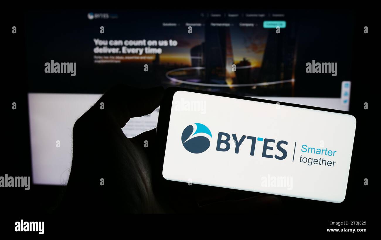 Person mit Smartphone und Logo des britischen Softwareunternehmens Bytes Technology Group plc vor der Website. Schwerpunkt auf dem Display des Telefons. Stockfoto
