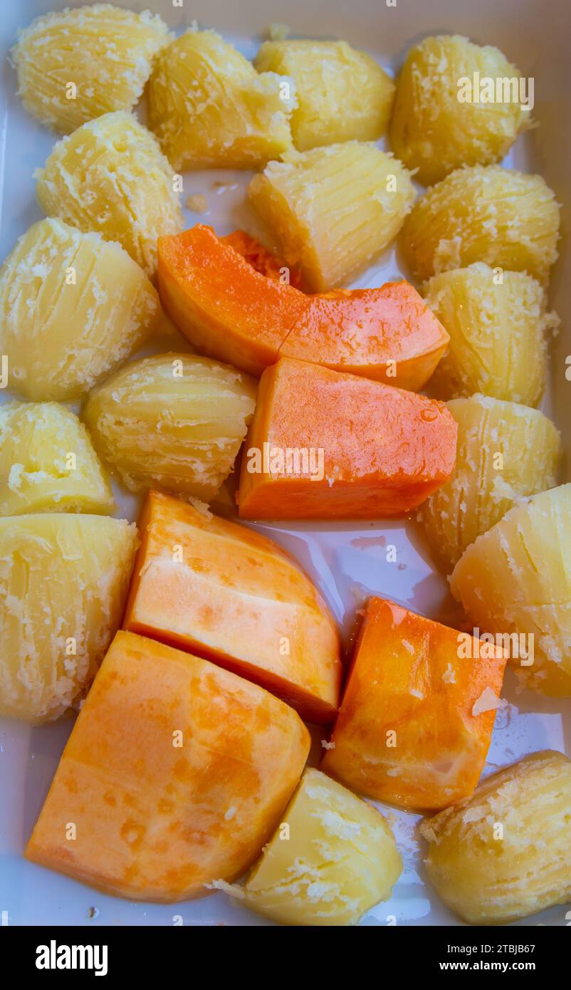 Kürbis und Kartoffeln in einer Ofenform braten und mit der Gabel knusprig schaben Stockfoto