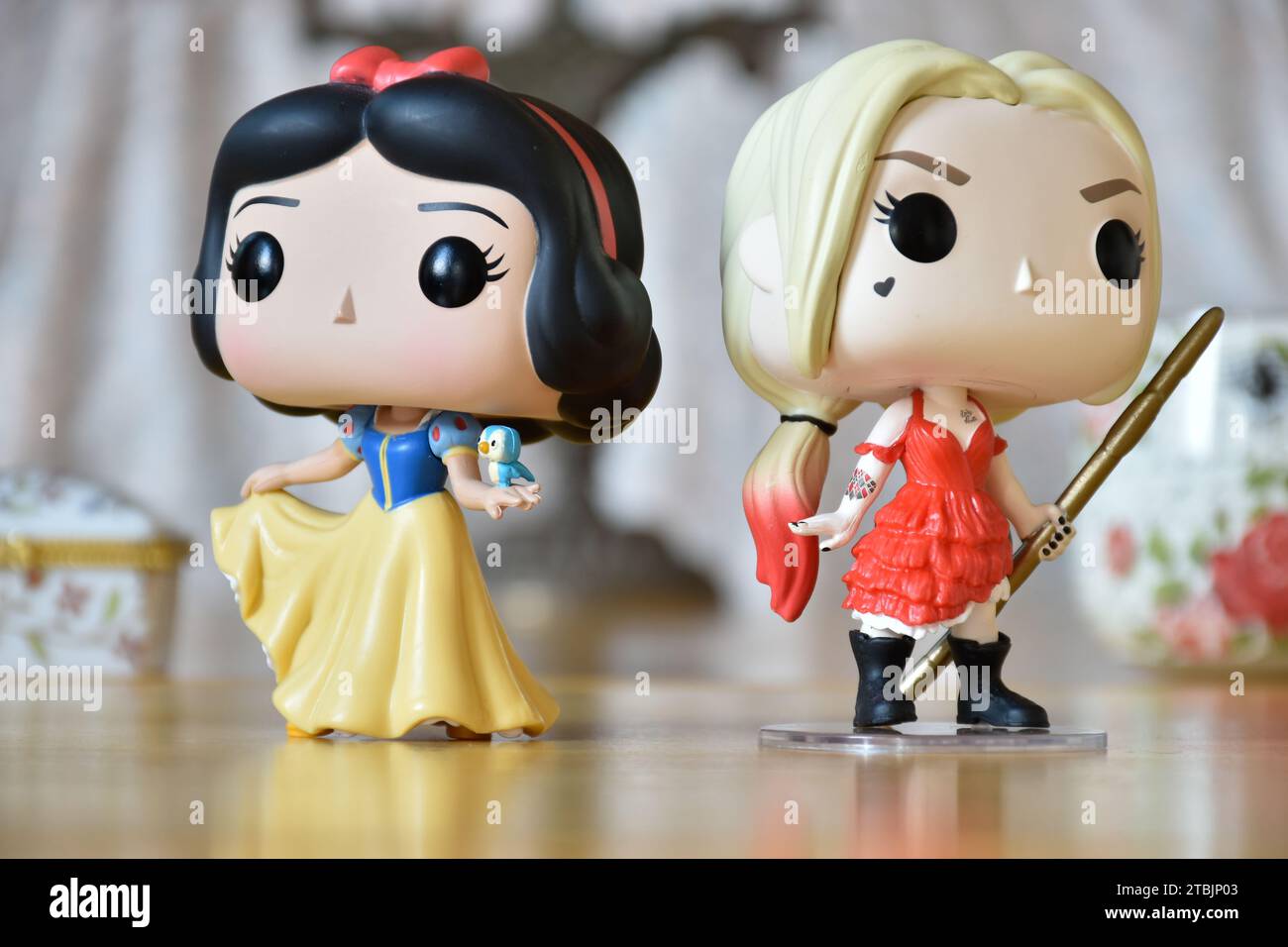 Funko Pop Actionfiguren der Disney-Prinzessin Snow White und DC-Superhelden Harley Quinn. Vintage-Einrichtung, helles Zimmer, Schmuckkästchen. Stockfoto