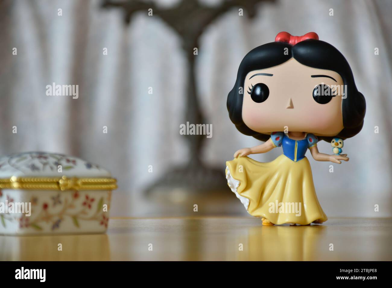 Funko Pop Actionfigur der Disney Prinzessin Schneewittchen. Vintage-Innenausstattung, alter Kerzenhalter, Schmuckschatulle mit weißem Blumenmuster. Stockfoto