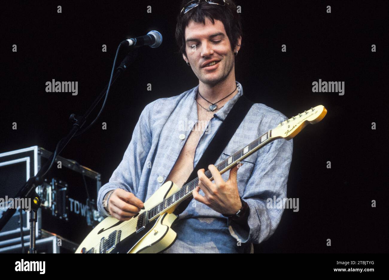 DANDY WARHOLS, READING FESTIVAL, 1999: Ein junger Courtney Taylor-Taylor von den Dandy Warhols verhöhnt und lächelt mit einer Lippenlocke von Elvis, während er am 29. August 1999 auf der Hauptbühne des Reading Festivals in Reading, Großbritannien spielt. Foto: Rob Watkins Stockfoto DANDY WARHOLS, READING FESTIVAL, 1999: Ein junger Courtney Taylor-Taylor von den Dandy Warhols verhöhnt und lächelt mit einer Lippenlocke von Elvis, während er am 29. August 1999 auf der Hauptbühne des Reading Festivals in Reading, Großbritannien spielt. Foto: Rob Watkins Stockfoto