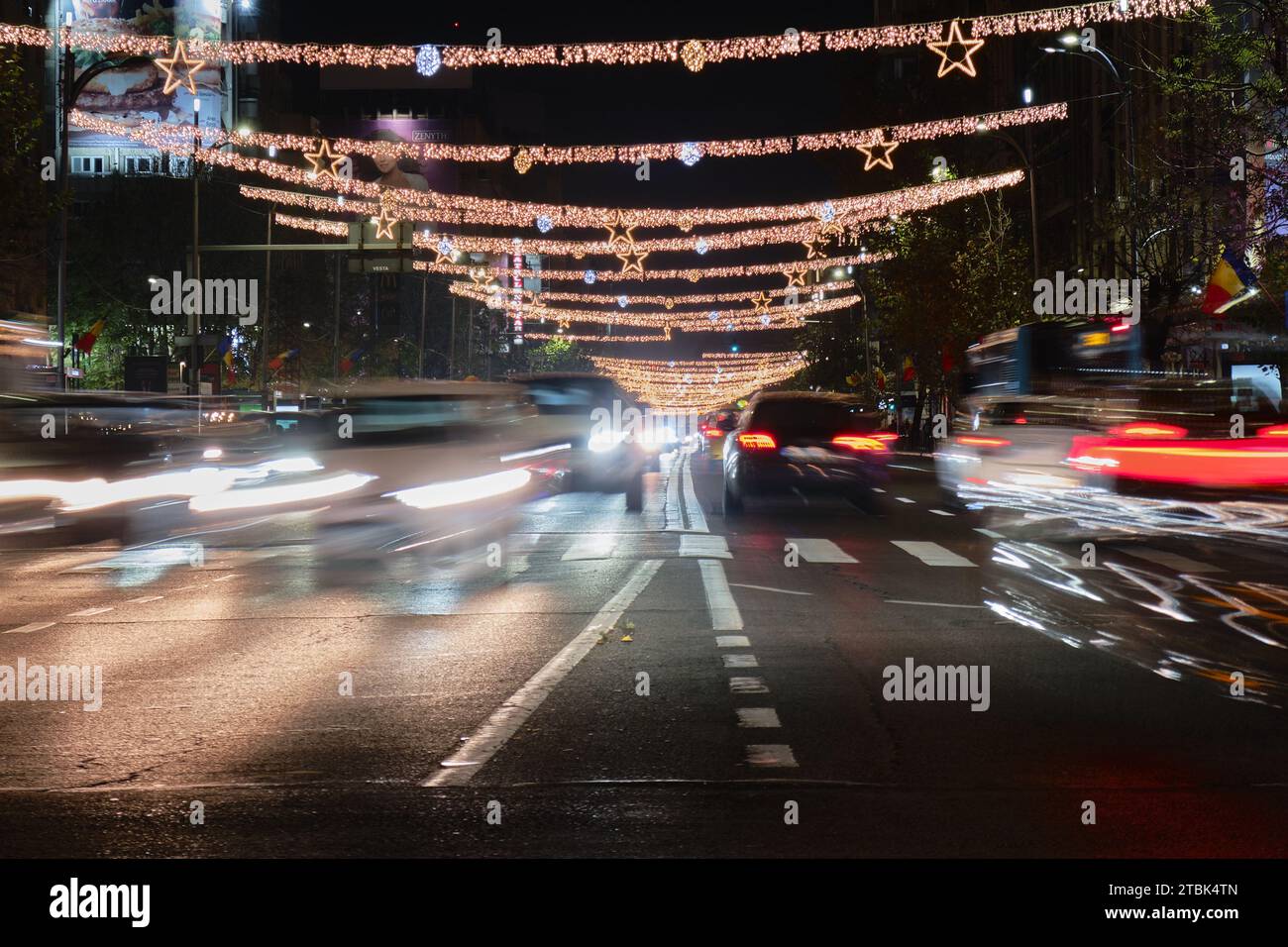 Winterliche Lichter mit entgegenkommendem und anhaltendem Autoverkehr bei Nacht auf dem sechsspurigen Magheru Boulevard, einer Hauptstraße in der rumänischen Hauptstadt. Bukarest, Rom Stockfoto