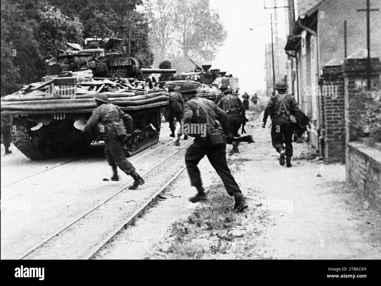 INVASIONSSOLDATEN der NORMANDIE greifen den Feind in Bella Riva östlich von Ouistreham an, unterstützt von Sherman-Panzern der B Squadron 13/18. Royal Husars. Am 6. Juni 1944. Foto: Sgt G Laws Stockfoto