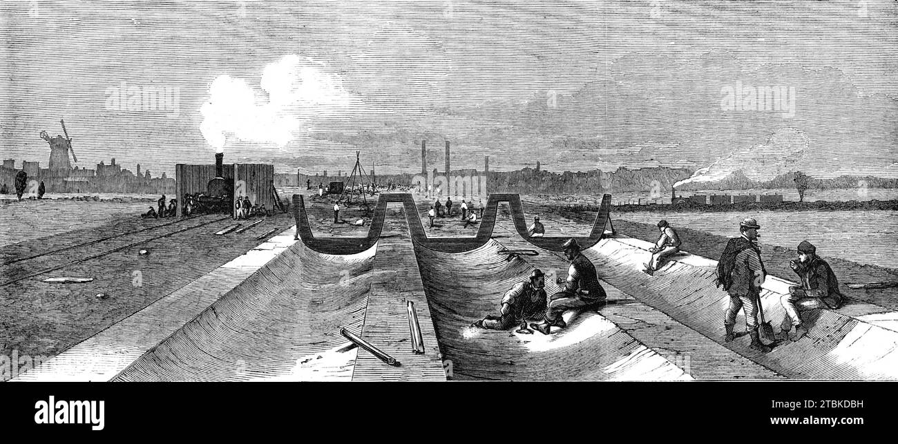 London Main Drainage: Betonfundament für die nördlichen Auslauftunnel, 1861. Die nördliche Kanalisation ist etwa fünf Meilen lang. Für die erste Meile besteht sie aus zwei Tunnellinien, die in einem erhöhten Damm eingeschlossen sind, und für den Rest der Entfernung drei Tunnellinien mit einem Durchmesser von jeweils neun Fuß. Er überquert mit eisernen Aquädukten sieben Äste des Flusses Lea...der gesamte Oberboden wird zuerst ausgehoben, dann bildet sich eine feste Betondämmung. An manchen Stellen ist dieser Damm etwa 20 Fuß tief und 100 Fuß breit. Sie wird durch Tragen gebildet Stockfoto