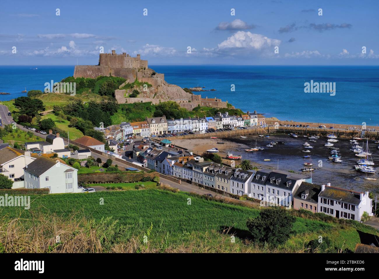 Gorey: Erhöhter Blick auf Mont Orgueil Castle, Dorf, Boote, Strand, Pier und Meer in Gorey, Jersey, Kanalinseln, Großbritannien Stockfoto