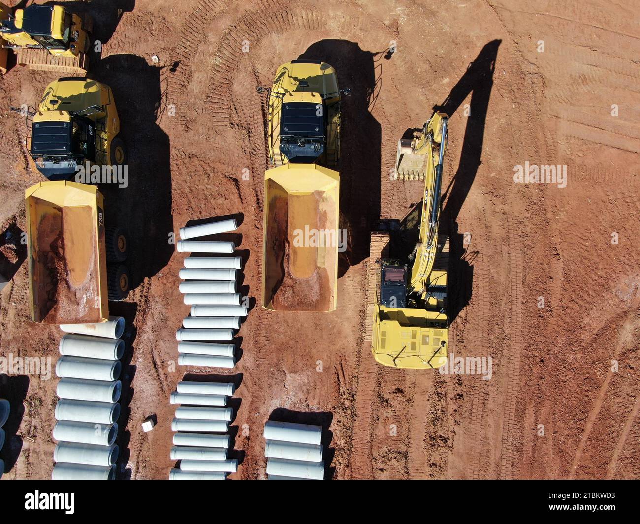 Drohnenbilder einer Baustelle mit Ausrüstung, Schmutz, Rückhalteteich, Wasser und Betonrohren. Stockfoto
