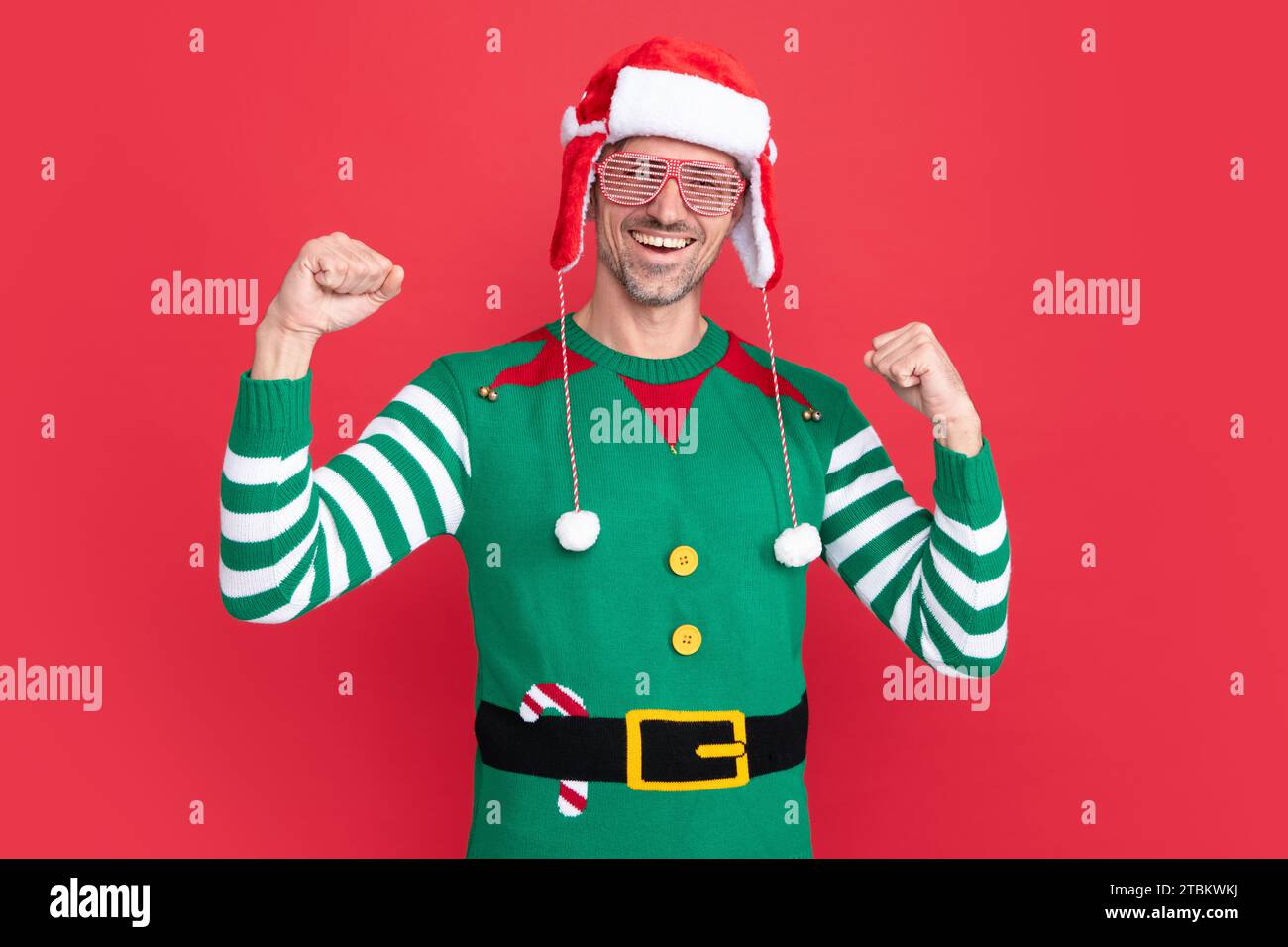 Positiv schreiender Mann in Elfenkostüm und Partybrille. weihnachtsmann mit weihnachtsmann-Hut Stockfoto