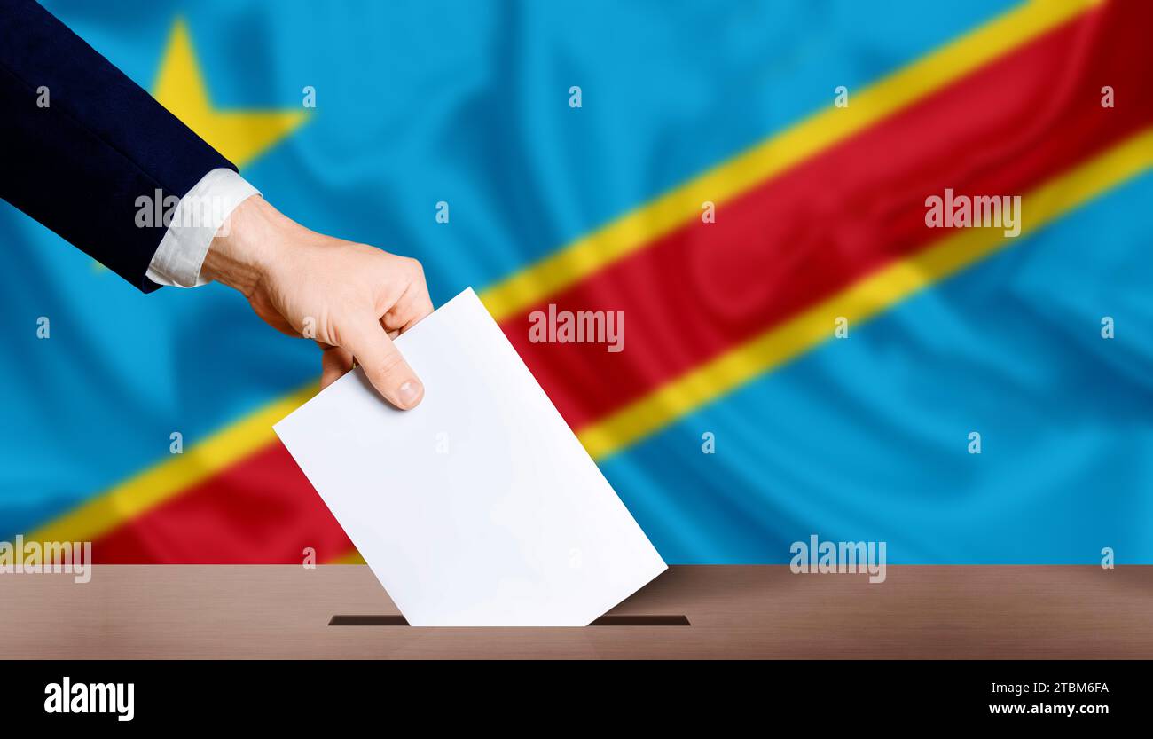 Hand in Stimmzettel mit Flagge der Demokratischen Republik Kongo im Hintergrund. Präsidentschaftswahlen der Demokratischen republik Stockfoto