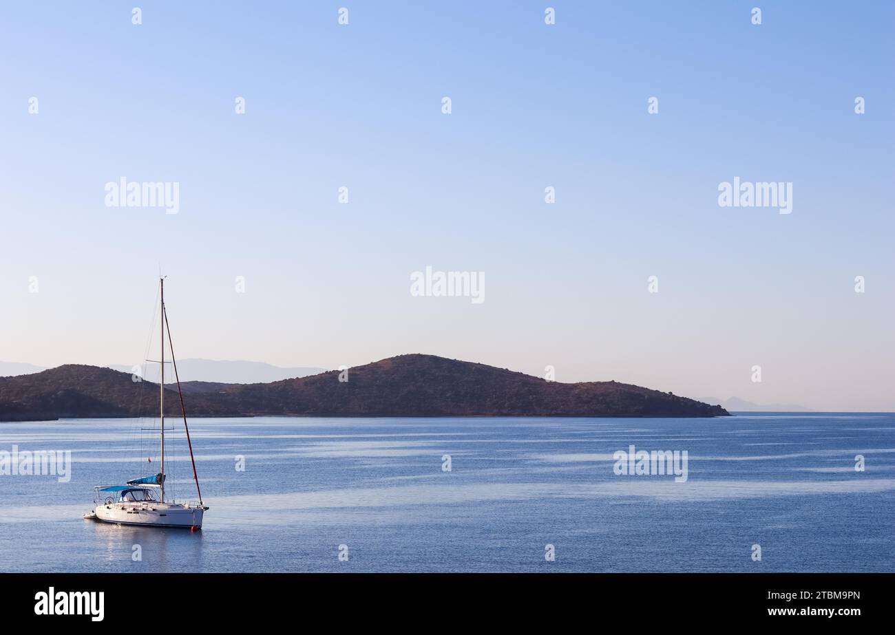 Blaues Meer, ein Boot und Berge bei Sonnenaufgang. Ruhiges Meereskonzept und Naturkonzept an der Küste Stockfoto