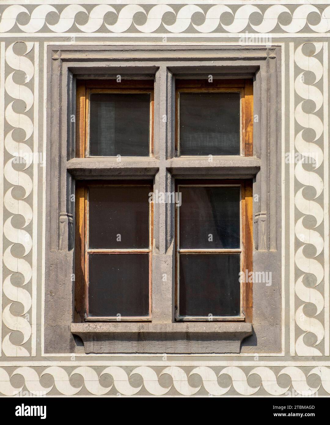 Alte Holzfenster im Vintage-Stil mit Verzierungen an der Wand. Außenansicht eines Gebäudes. Fenster im klassischen europäischen Stil in einem alten Gebäude Stockfoto