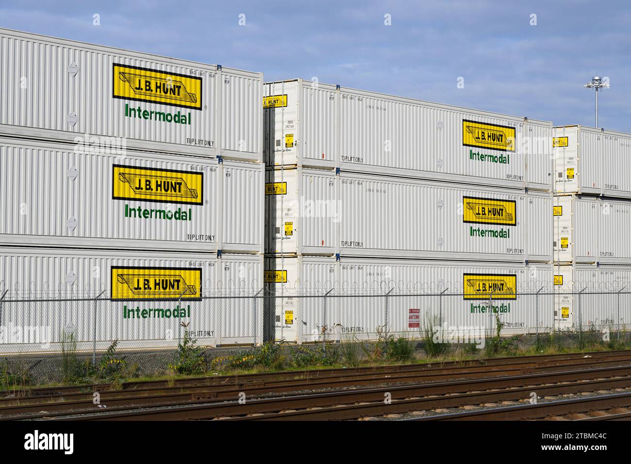 Everett, WA, USA - 11. November 2023; J B Hunt, weiße Container, die neben Bahngleisen gestapelt sind Stockfoto