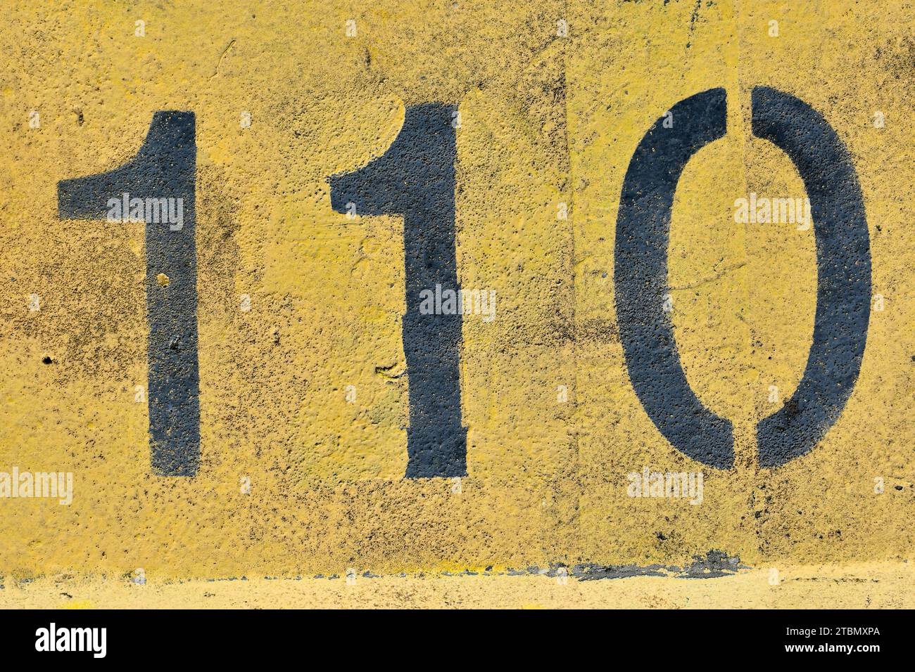 Die Zahl 110, hundert und zehn; gemalt in Schwarz und Gelb; abstrakter Hintergrund für grafische Gestaltung ein Symbol für Geburtstage, Daten, Jahrestage. Stockfoto