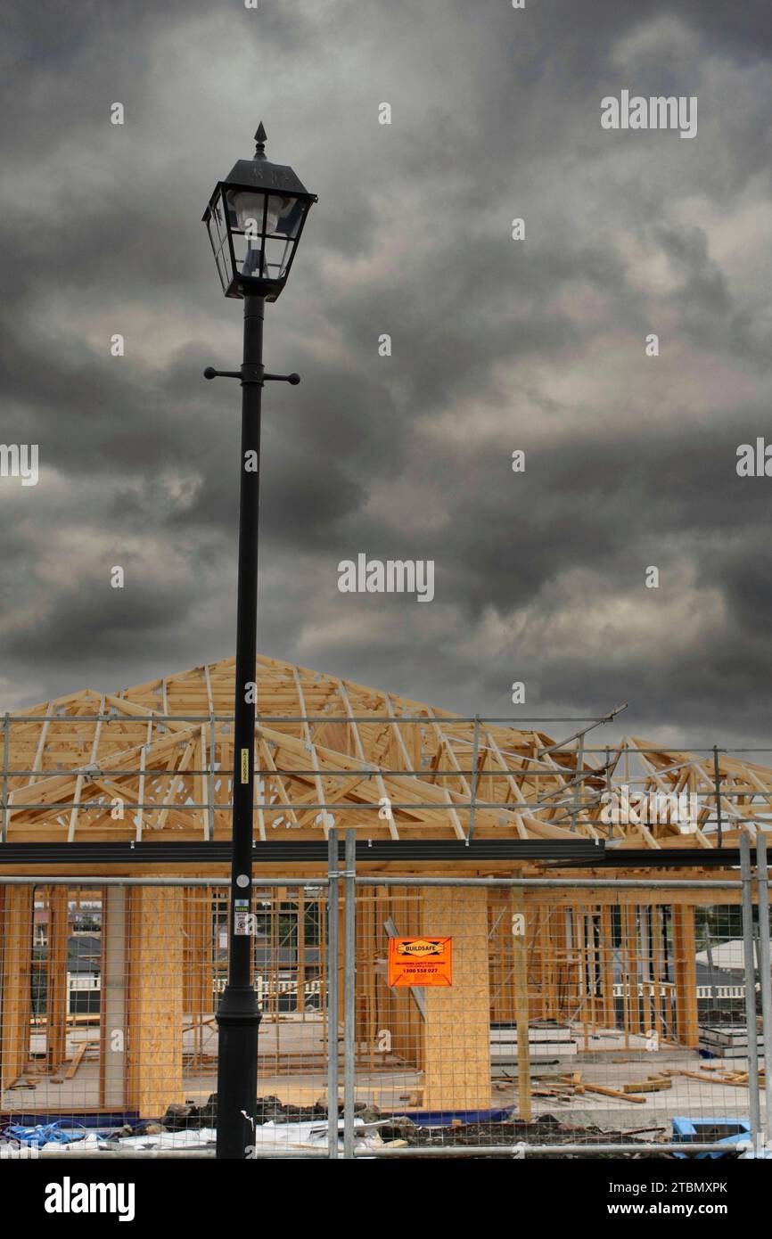 Wohnvorstadthaus im Hochbau mit stürmischem Himmel; Symbol für Bauindustrie, Immobilienmarkt, Wohnen und Immobilien Stockfoto