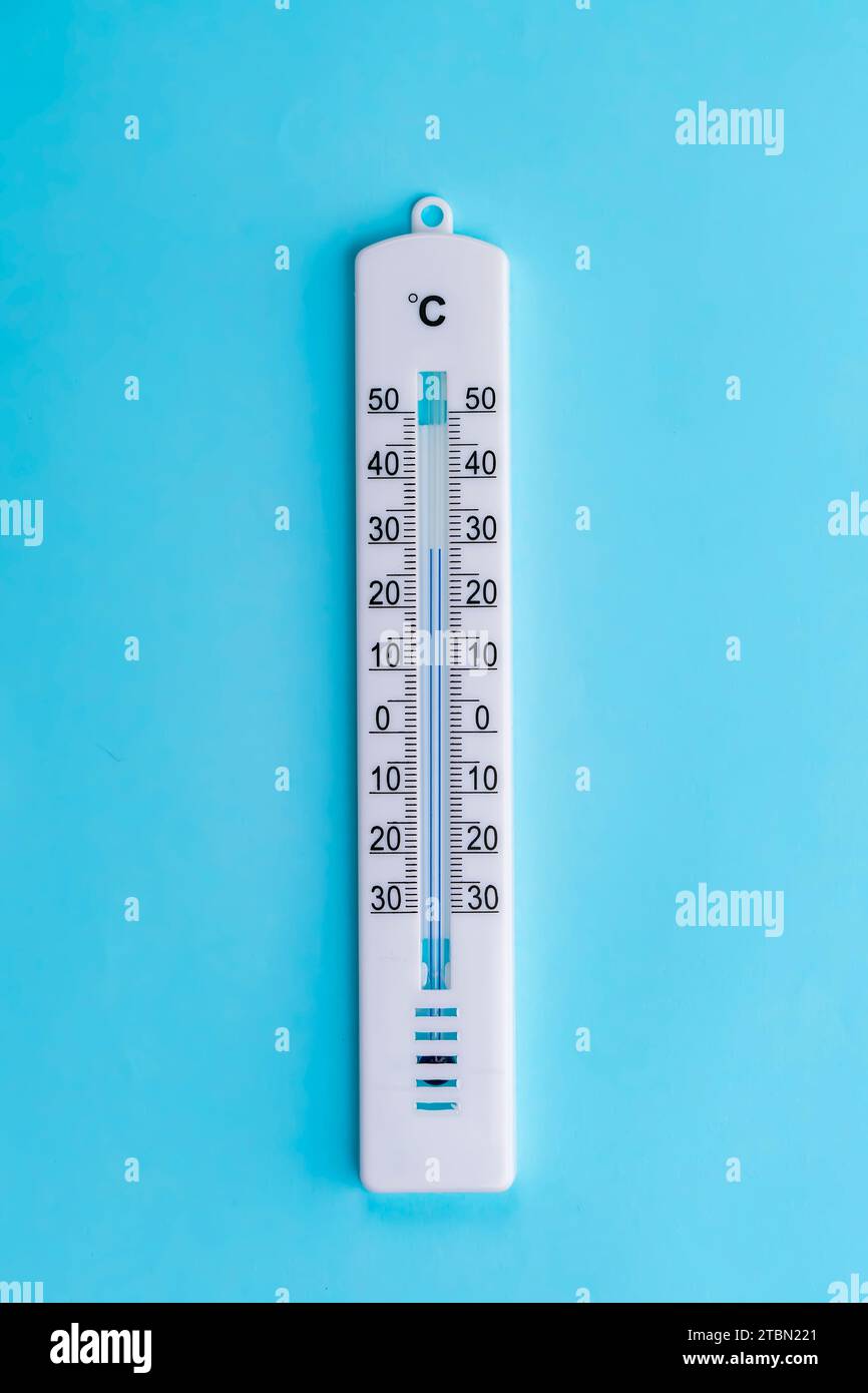 Thermometer hängt auf blauem Hintergrund Stockfoto