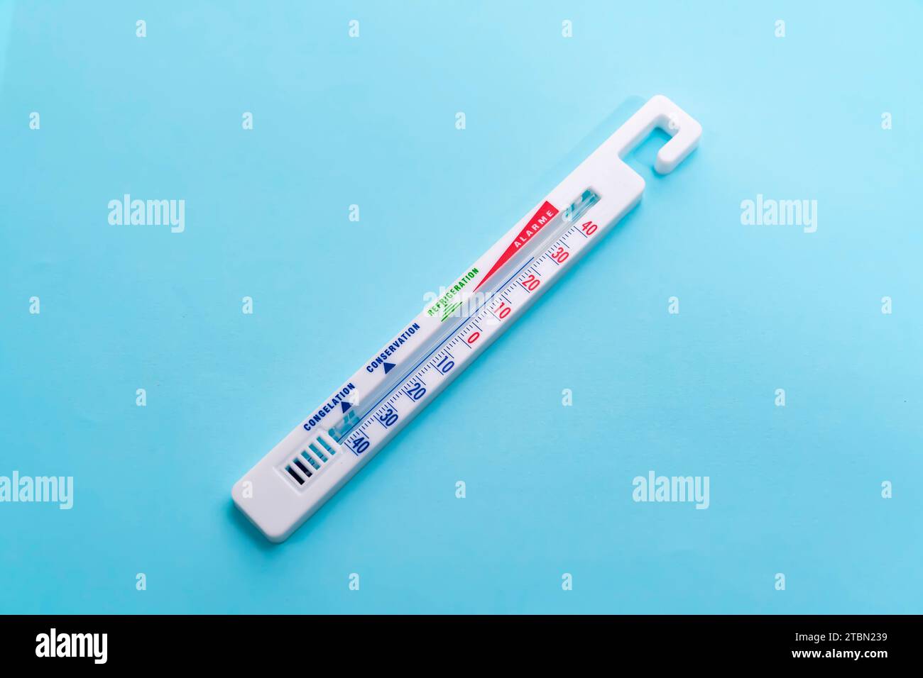 Thermometer hängt auf blauem Hintergrund Stockfoto