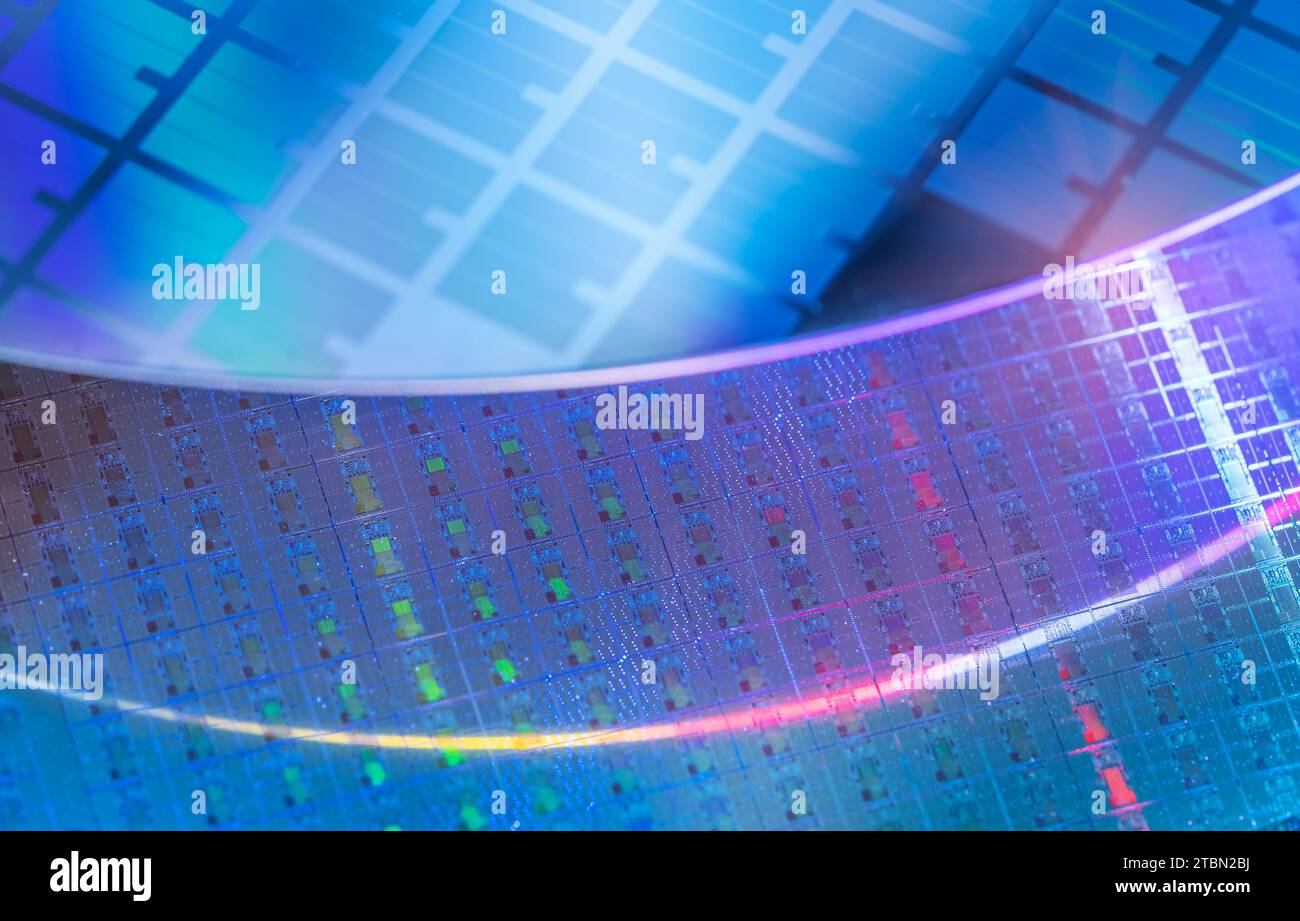 Blauer Siliziumwafer mit Mikrochips, die in der Elektronik zur Herstellung integrierter Schaltungen verwendet werden. Stockfoto