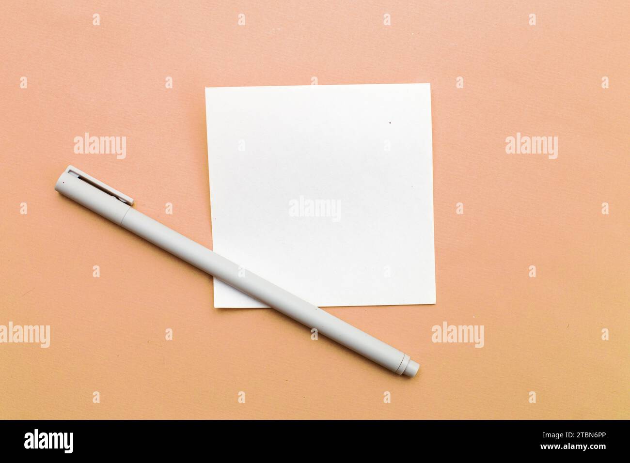 Draufsicht des leeren Notizpapiers mit Stift auf Peach Fuzz Hintergrund. Kopieren Sie den Platz für Ihren Text. Ideen schreiben, To-Do-Liste oder Plankonzept. Farbe des YA Stockfoto
