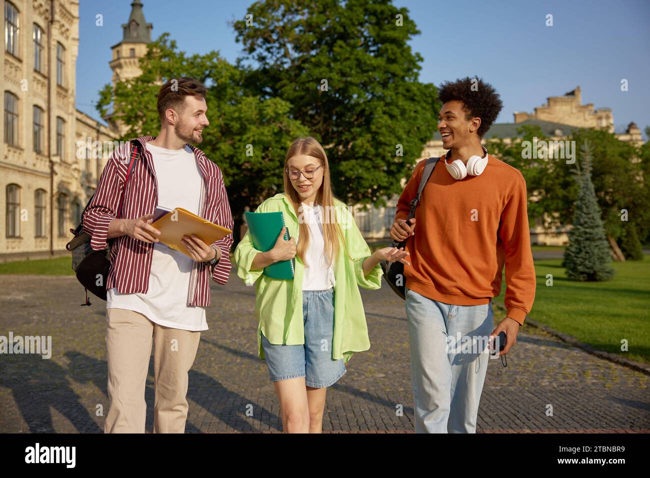 Internationale Gruppe intelligenter Schüler, die sich im Freien unterhalten Stockfoto