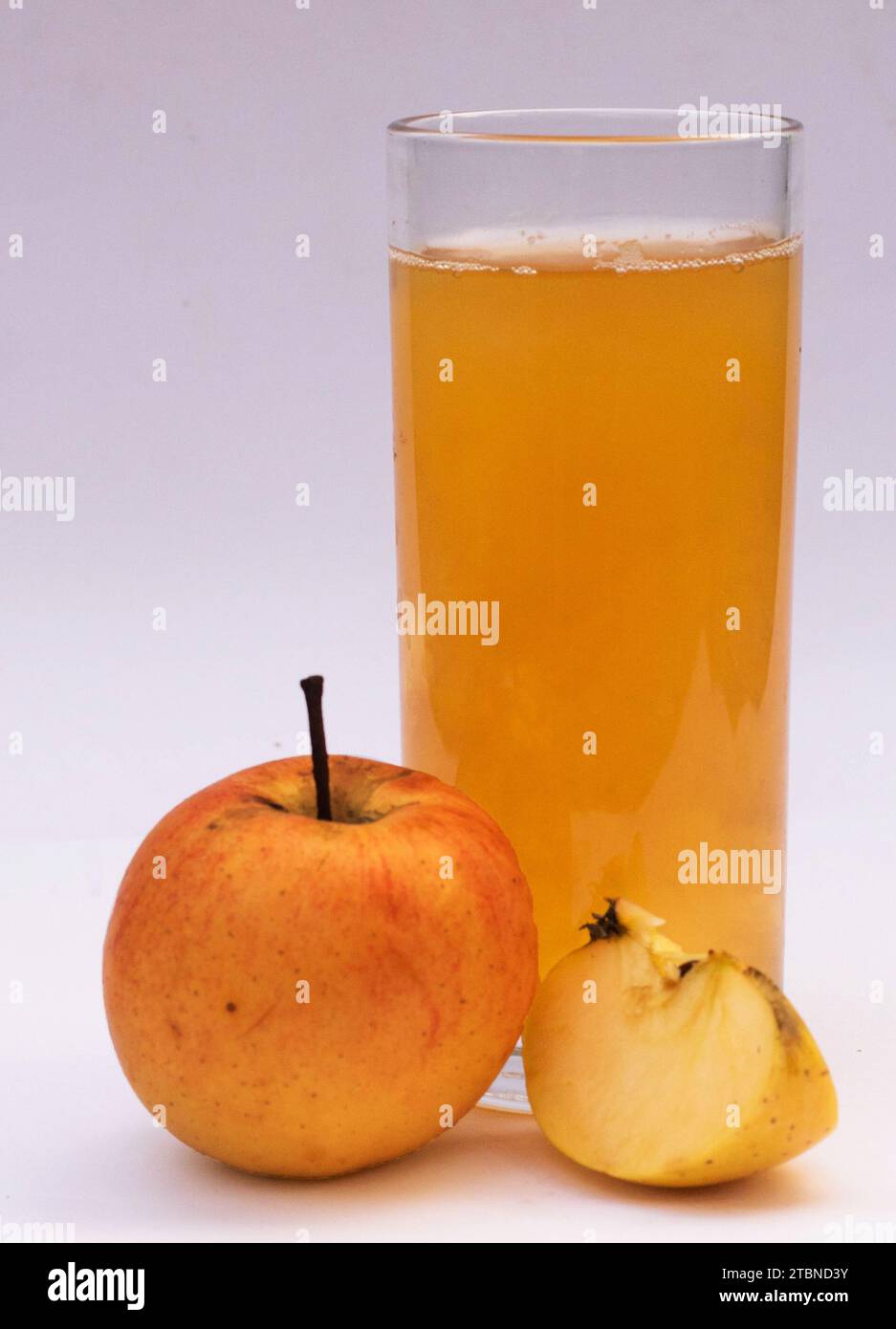 Apfelsaft im Glas isoliert, rote Äpfel isoliert auf weißem Hintergrund. Stockfoto