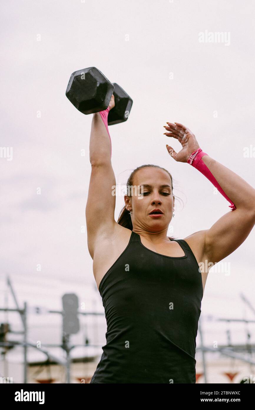 CrossFit-Wettbewerb für Damen. Frau mit Kurzhanteln. Stockfoto