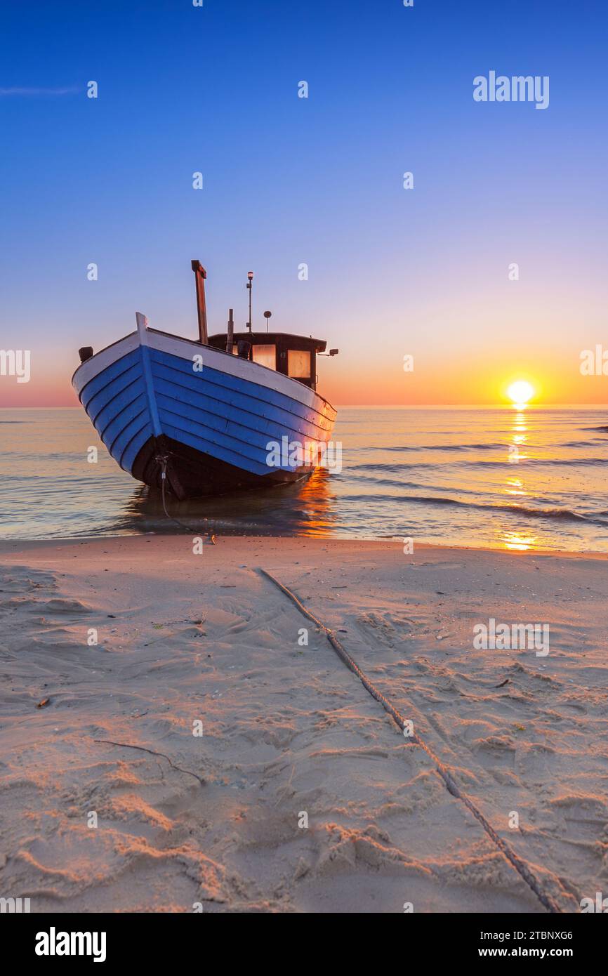 Altes hölzernes Fischerboot am Strand der Ostsee auf der Insel Usedom bei Sonnenaufgang Stockfoto