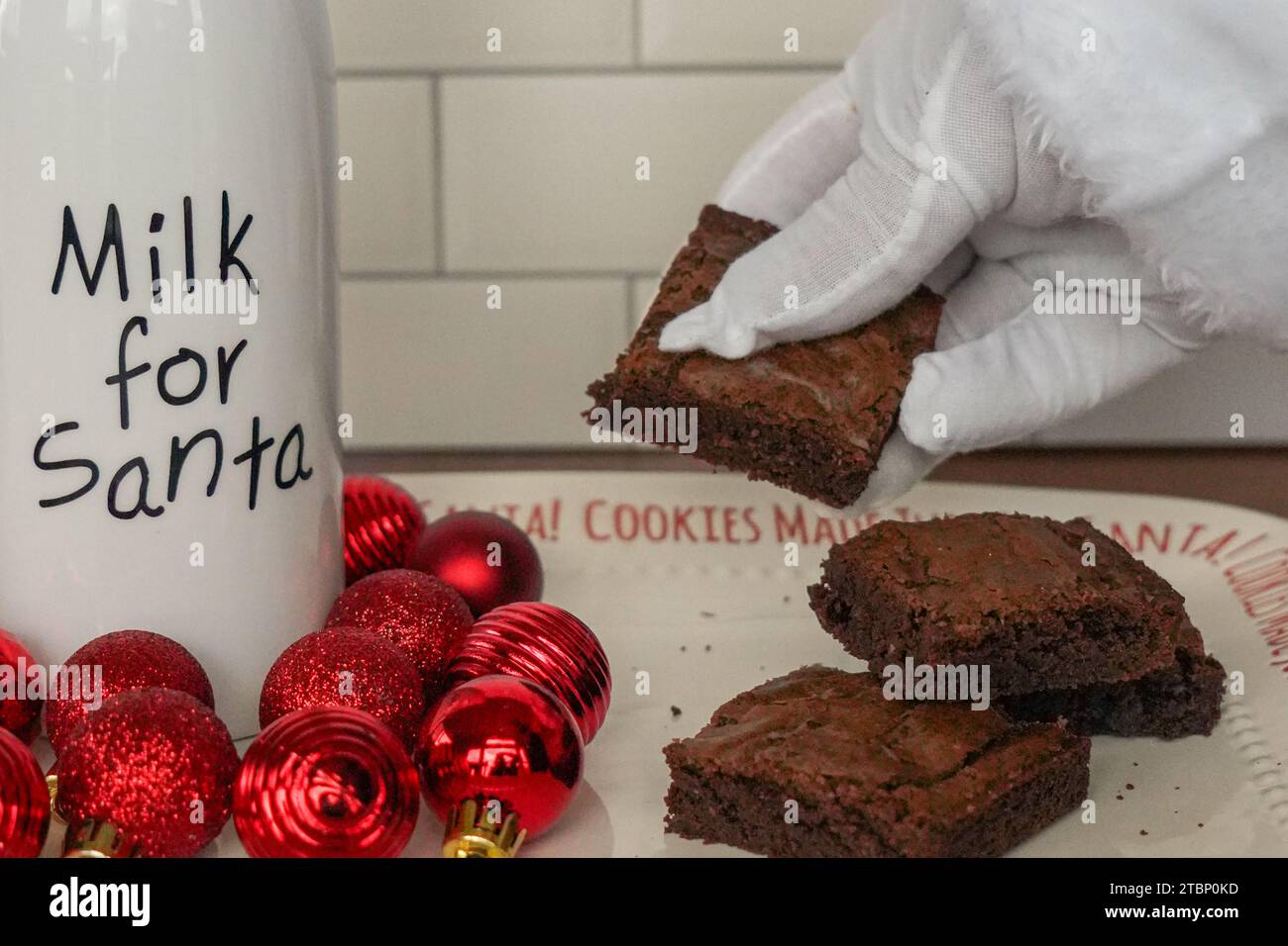 Nahaufnahme des weihnachtsmanns mit einem Brownie in der Hand und einer Flasche Milch Stockfoto