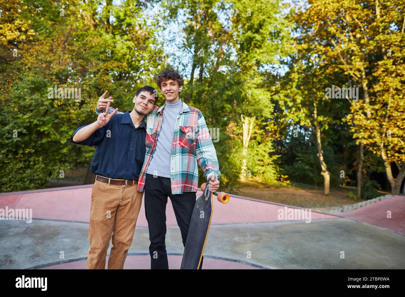 Zwei Teenager machen Siegeszeichen in einem Skatepark Stockfoto