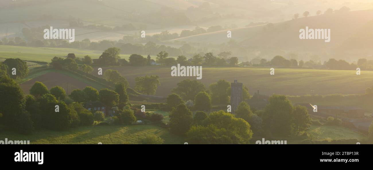 St. Swithun's Church und die umliegende Landschaft bei Sonnenaufgang, Shobrooke, Mid Devon, England. Frühjahr (Mai) 2023. Stockfoto