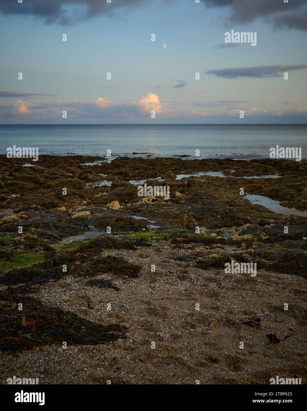 Der Mond beginnt über dem Meer zu zeigen Stockfoto