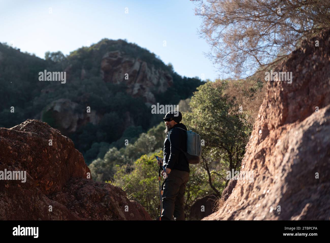 Ein Mann mittleren Alters betrachtet die Landschaft des Garraf Natural Park, während er auf den Wanderwegen eines Berges spaziert. Stockfoto