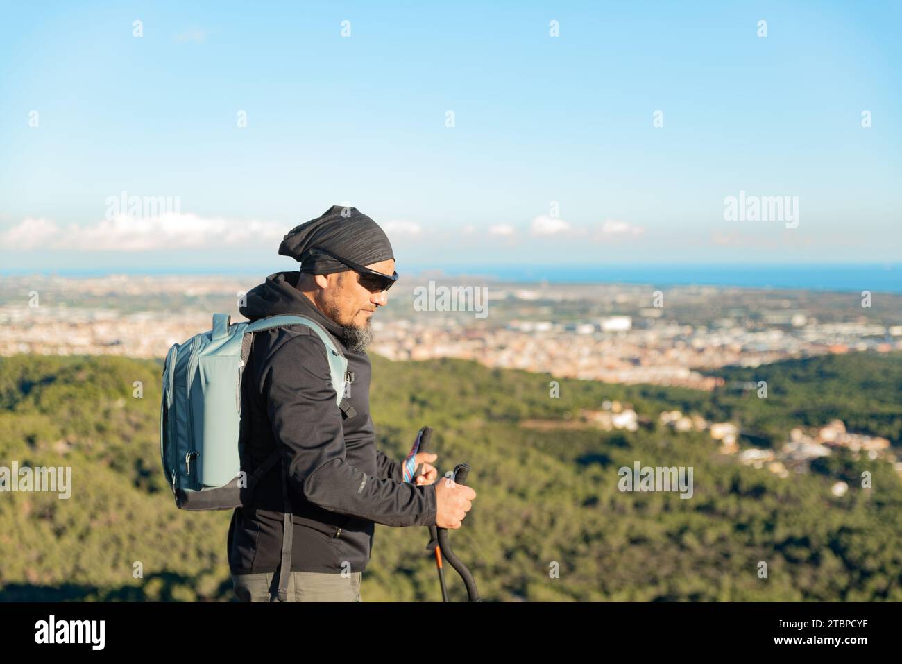 Ein Mann mittleren Alters betrachtet die Landschaft des Garraf Natural Park, während er auf den Wanderwegen eines Berges spaziert. Stockfoto