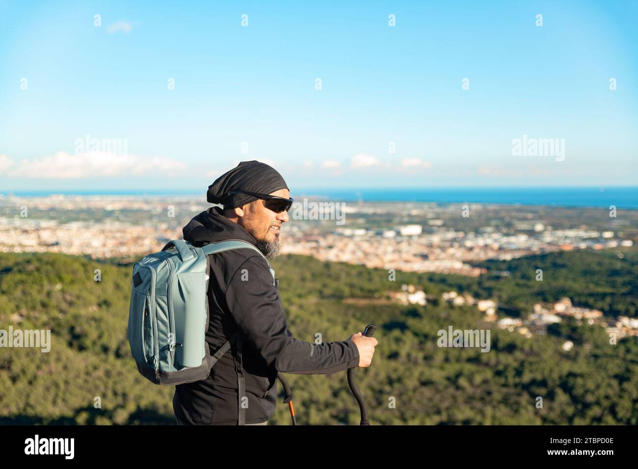 Ein Mann mittleren Alters betrachtet die Landschaft des Garraf Natural Park, während er auf den Wanderwegen eines Berges spaziert. Stockfoto