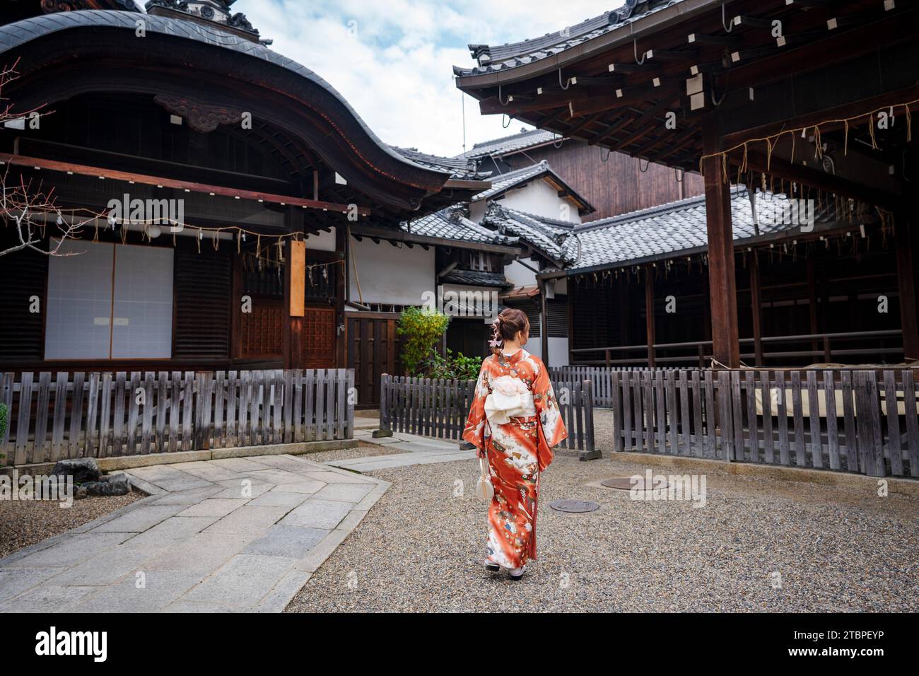 Japanischer Kimono Porträt Rückansicht. Kyoto, Japan. Traditionelle japanische Gebäude im Hintergrund. Stockfoto