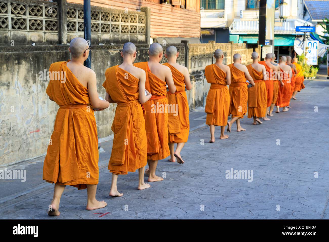 Lampang, Thailand - 2. Dezember 2023: Thai Theravada buddhistische Mönche gehen für Morgenalmen in Nakhon Lampang, Thailand. Stockfoto